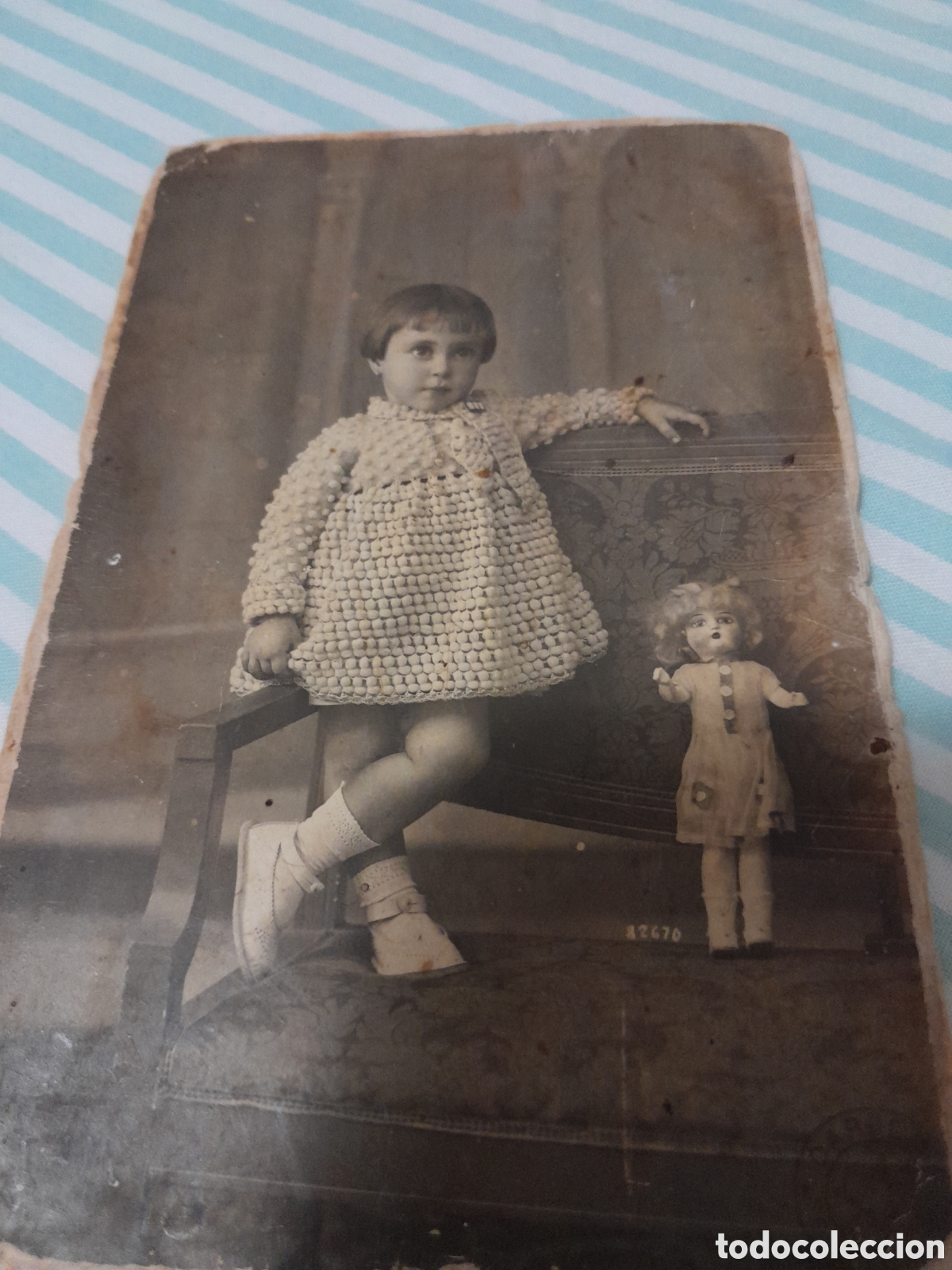 Fotograf&iacute;a antigua: Fotograf&iacute;a de una ni&ntilde;a peque&ntilde;a posando con un vestido blanco de punto a du lado una mu&ntilde;eca