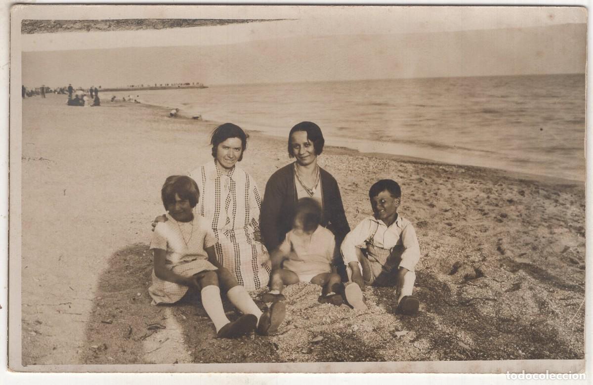 Fotograf&iacute;a antigua: Foto tarjeta. Dos mujeres elegantes con dos ni&ntilde;as y un ni&ntilde;o sentados en la playa, hacia 1930
