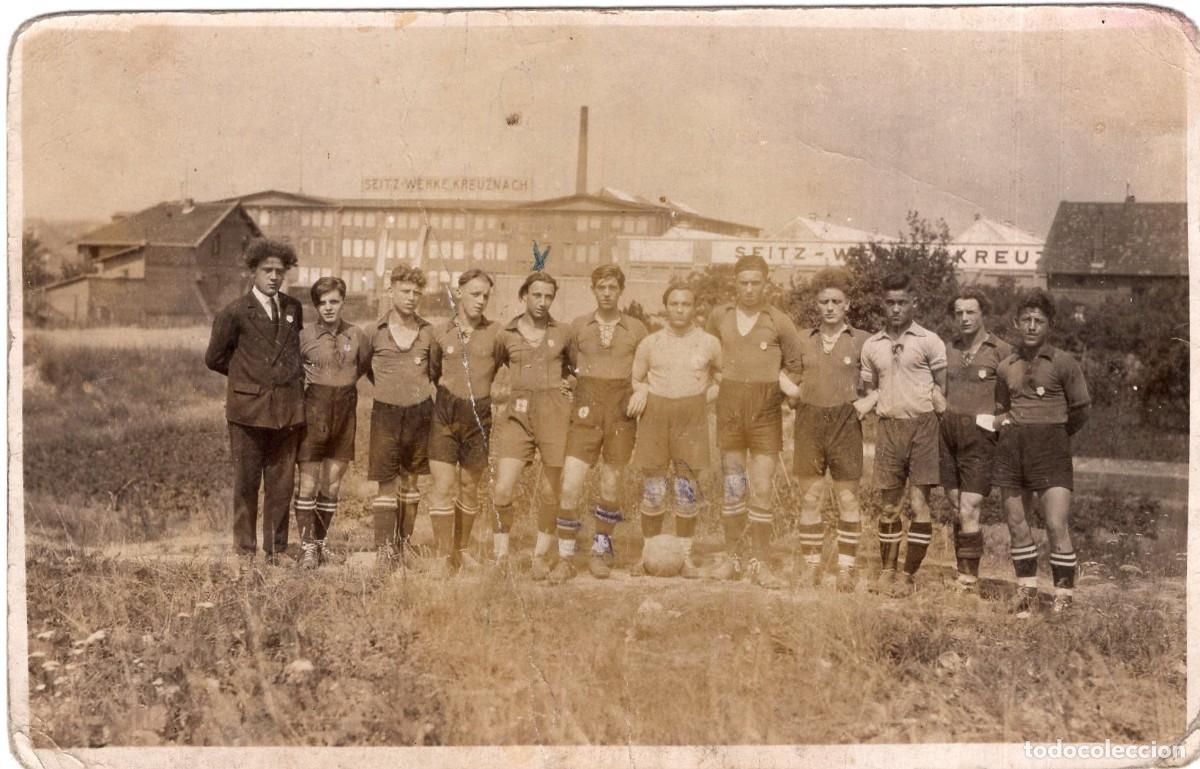 Fotografia antiga: Tarjeta fotogr&aacute;fica equipo de f&uacute;tbol en el campo con la f&aacute;brica Seitz-Werke en Bad Kreuznach