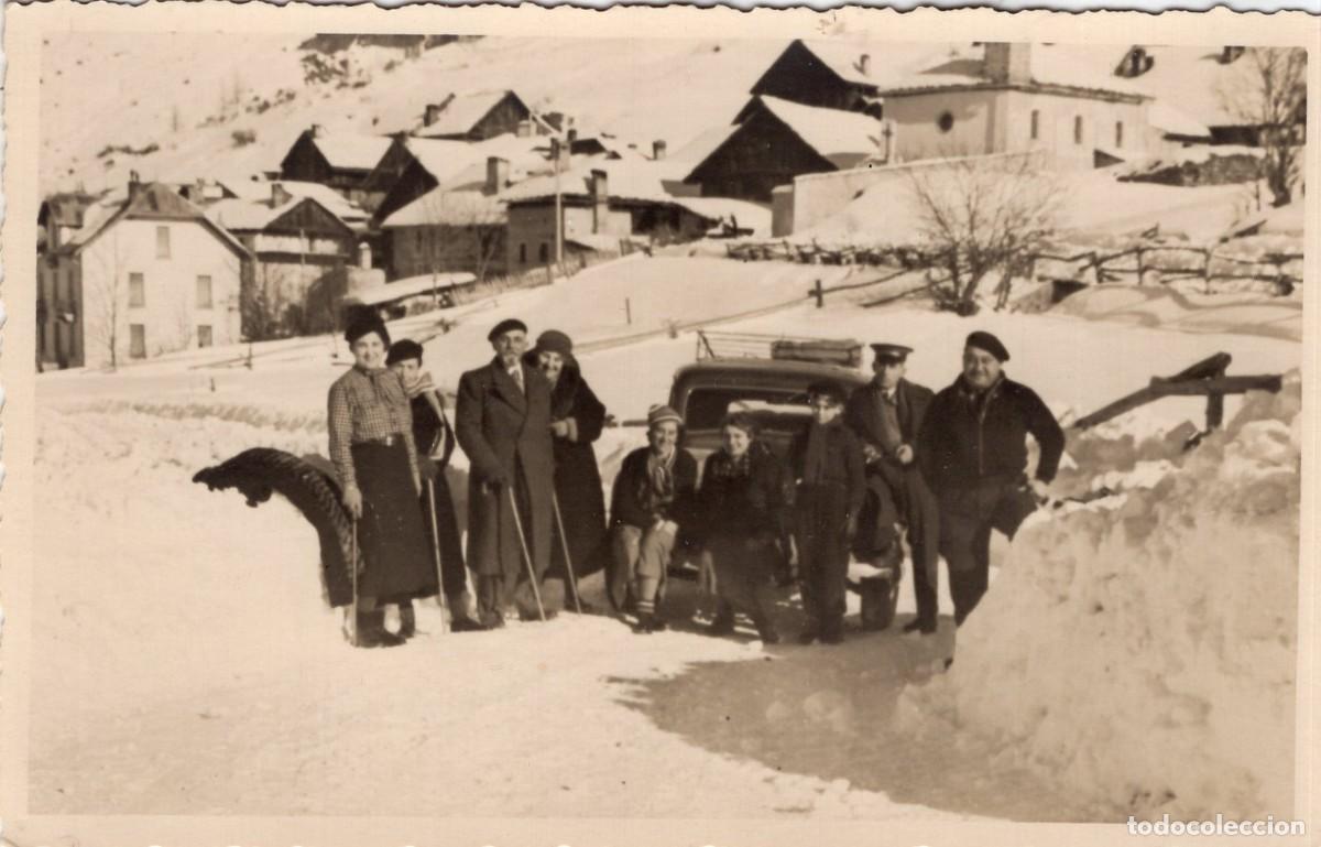 Fotograf&iacute;a antigua: Tarjeta fotogr&aacute;fica de una familia con su coche en una carretera nevada de un pueblo
