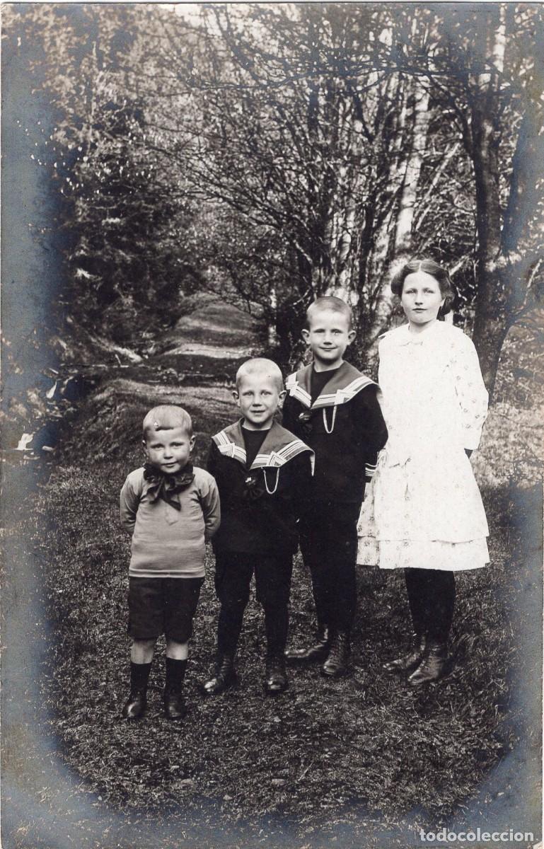 Fotograf&iacute;a antigua: Tarjeta fotogr&aacute;fica de joven elegante con tres ni&ntilde;os posando en un bosque c.1910
