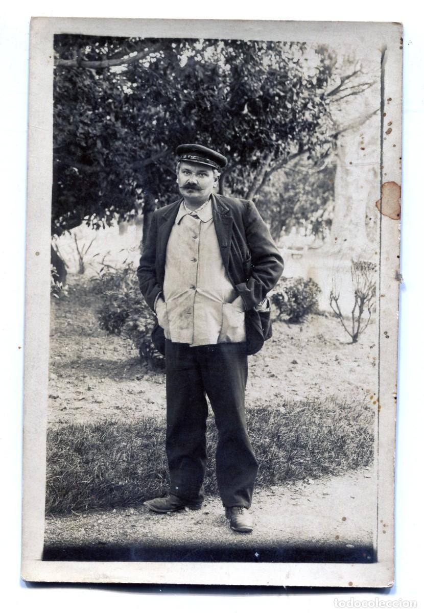 Fotograf&iacute;a antigua: Tarjeta fotogr&aacute;fica de un hombre en uniforme de ferroviario posando ante un jard&iacute;n en 1914