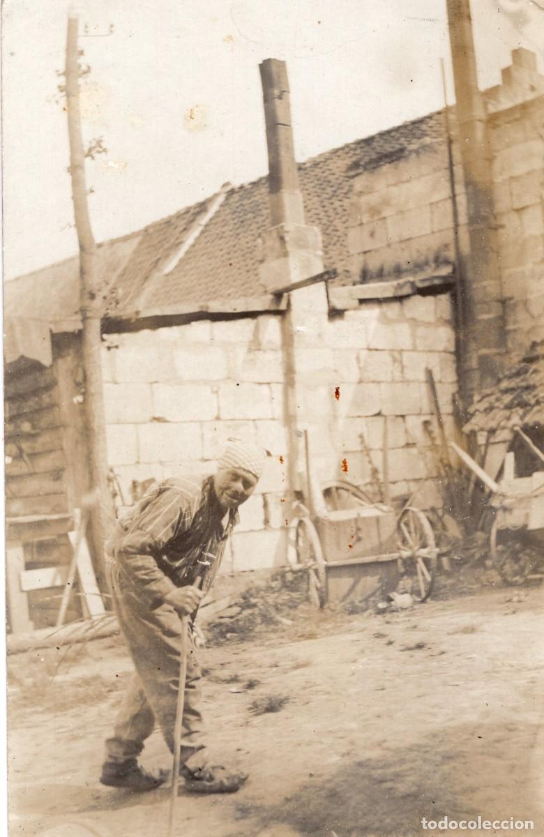 Fotograf&iacute;a antigua: Tarjeta fotogr&aacute;fica de una campesina caminando en el patio de su granja.