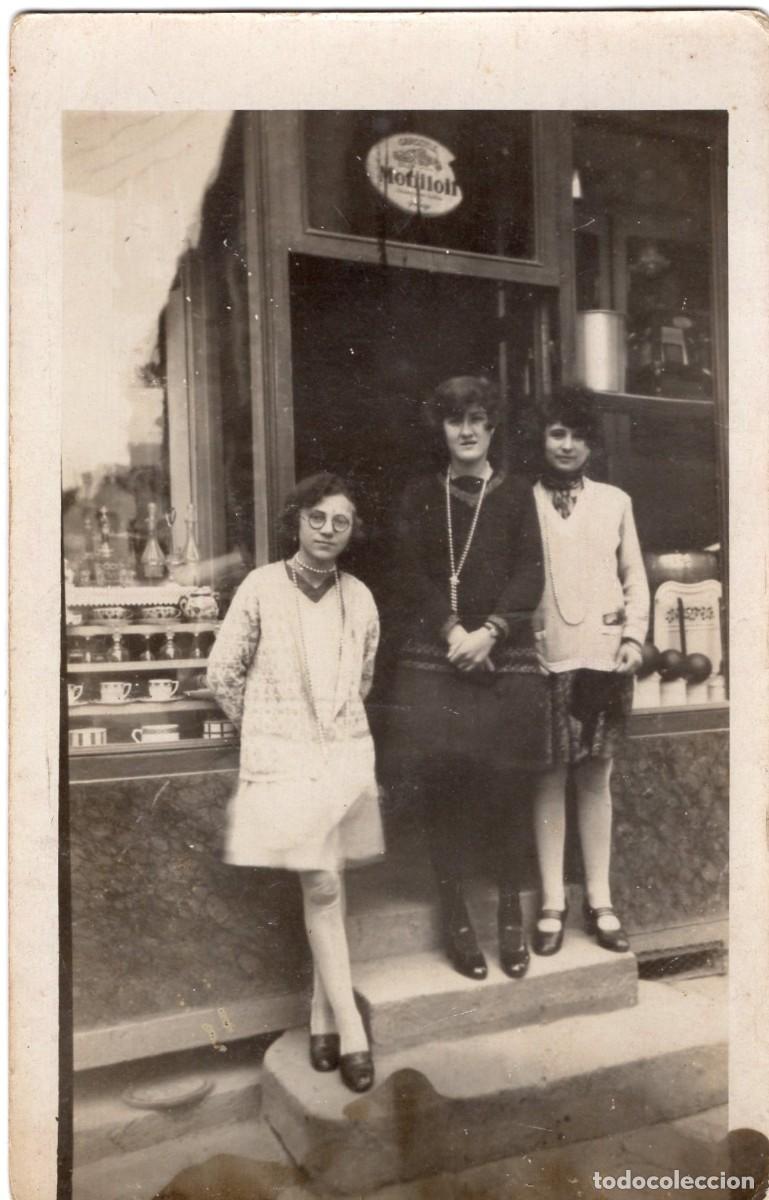 Fotograf&iacute;a antigua: Tarjeta foto: mujer elegante con dos hijas ante su tienda en una ciudad hacia 1930.