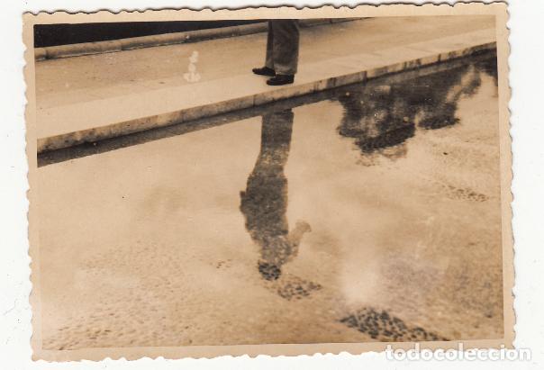 Fotograf&iacute;a antigua: Reflejo de un transe&uacute;nte en la calzada mojada - Composici&oacute;n fotogr&aacute;fica