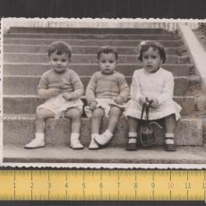 Fotografía antigua: SIMPÁTICOS TRIO NIÑOS Y NIÑA SENTADOS ESCALERA - FOTO ANTIGUA AÑO 1952 MADRID - SONRISA LAZO BOLSO