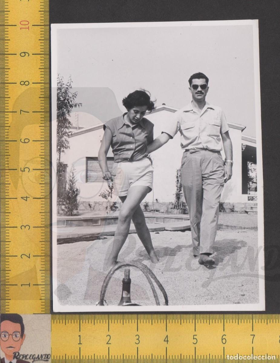Fotografia antica: ELEGANTE PAREJA PASEA POR JARD&Iacute;N - HOMBRE Y MUJER DESCALZOS POR ARENA - FOTO ANTIGUA A&Ntilde;O 1958