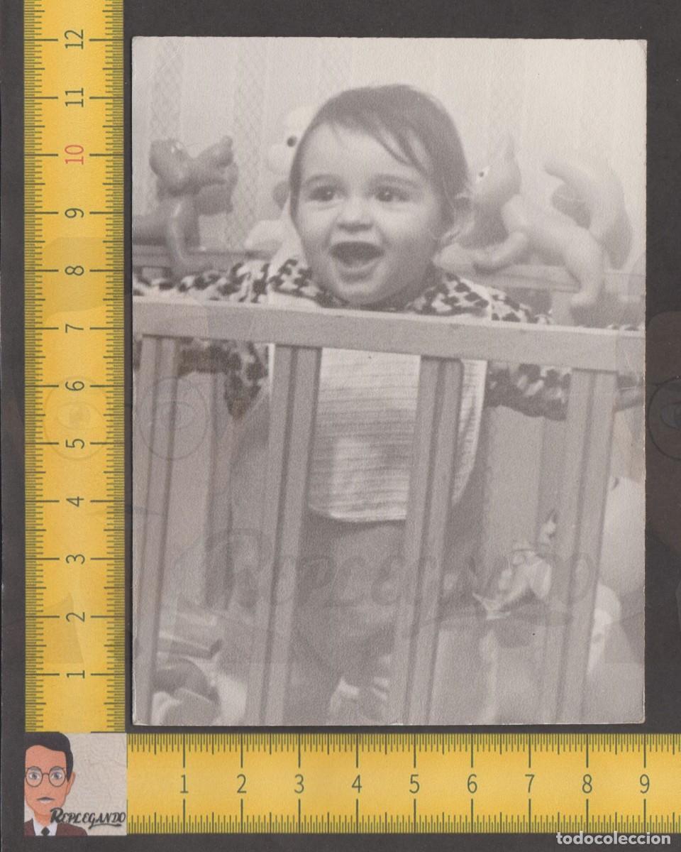 Fotografia antica: SIMP&Aacute;TICA NI&Ntilde;A SONRIE EN SU CUNA RODEADA DE MU&Ntilde;ECOS JUGUETE - FOTO ANTIGUA A&Ntilde;O 1974 - INFANCIA