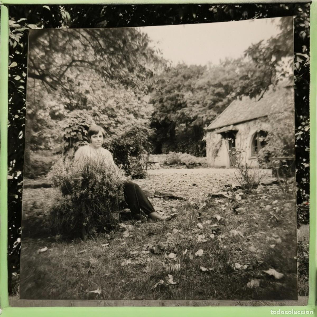 Fotograf&iacute;a antigua: Fotograf&iacute;a Vintage En Blanco Y Negro &ndash; Mujer Sentada En Jard&iacute;n R&uacute;stico Con Caba&ntilde;a Al Fondo