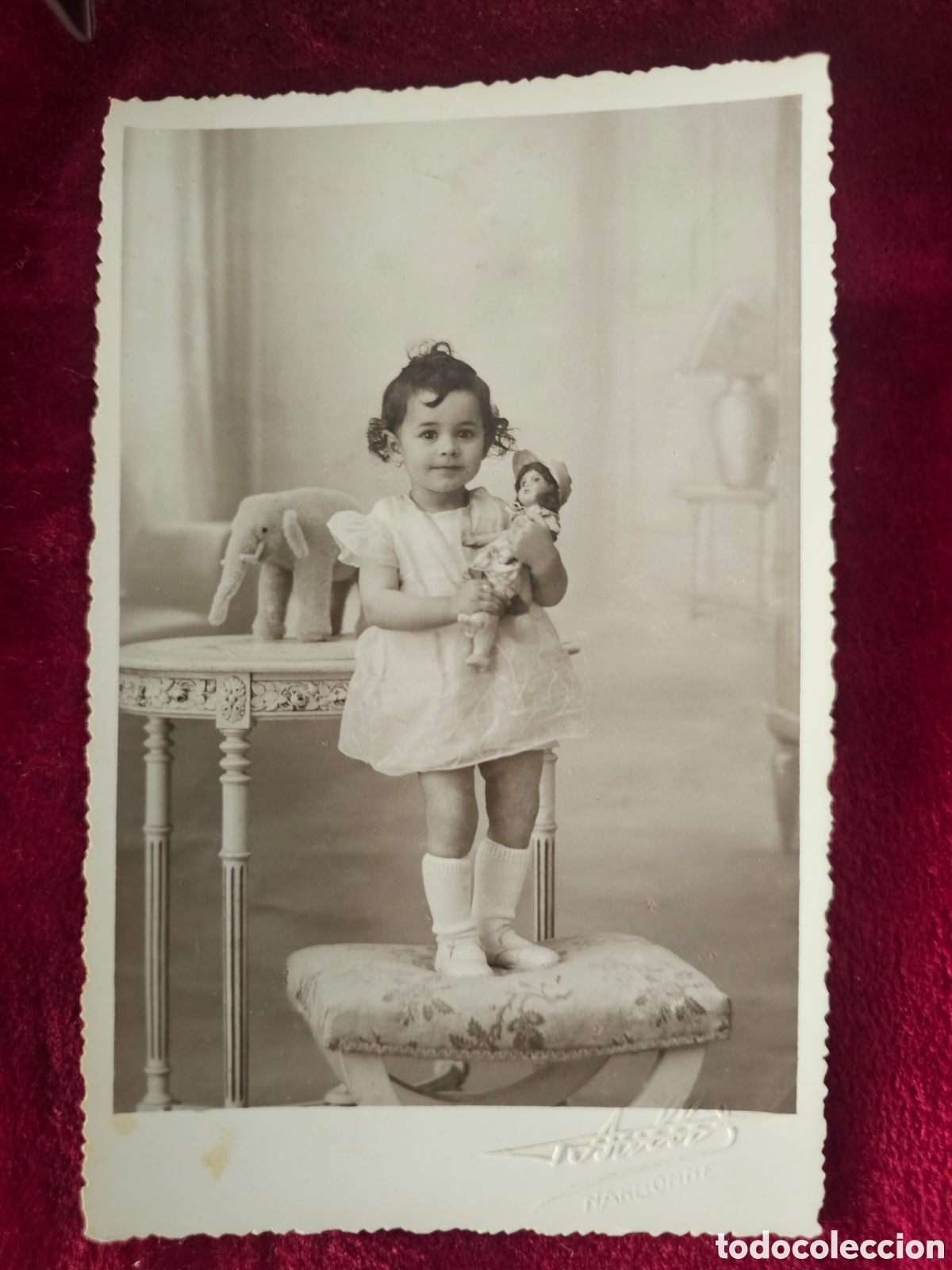 Fotograf&iacute;a antigua: ​Fotograf&iacute;a antigua de estudio &ndash; Ni&ntilde;a con mu&ntilde;eca y elefante (Narbonne, Francia, c. 1920-1940)
