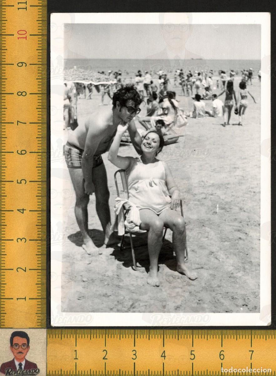 Fotograf&iacute;a antigua: PAREJA JOVEN BA&Ntilde;ISTAS EN PLAYA - HOMBRE BA&Ntilde;ADOR MUJER SENTADA SONRIENTE - FOTOGRAF&Iacute;A ANTIGUA A&Ntilde;OS 60