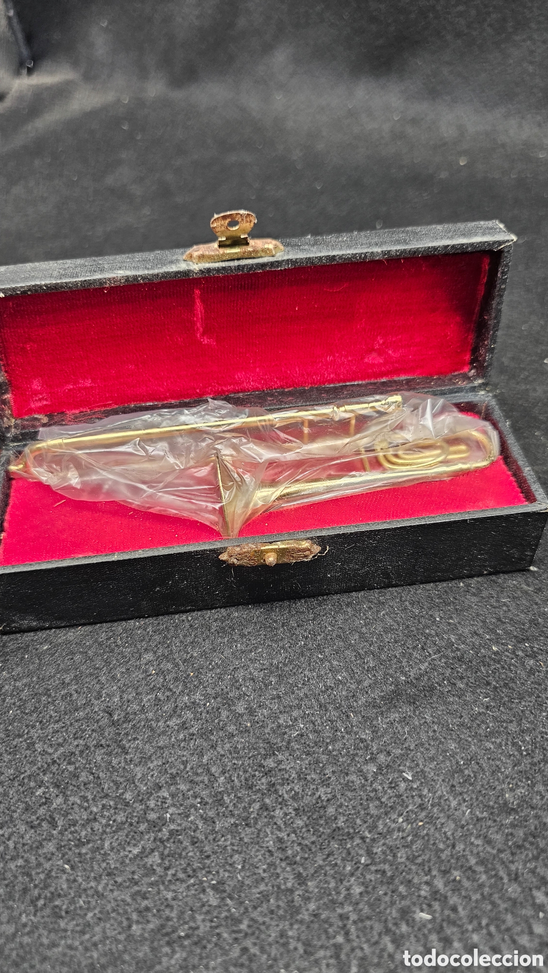 Instrumentos musicales: Antiguo tromb&oacute;n de metal en miniatura
