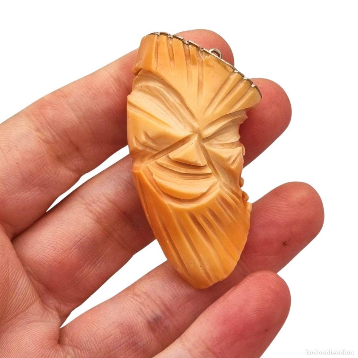 Joyeria: Colgante oriental con forma de m&aacute;scara tallada en coral piel de &aacute;ngel y plata, circa 1960-70