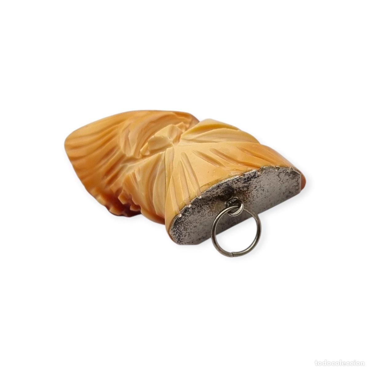 Joyeria: Colgante oriental con forma de m&aacute;scara tallada en coral piel de &aacute;ngel y plata, circa 1960-70