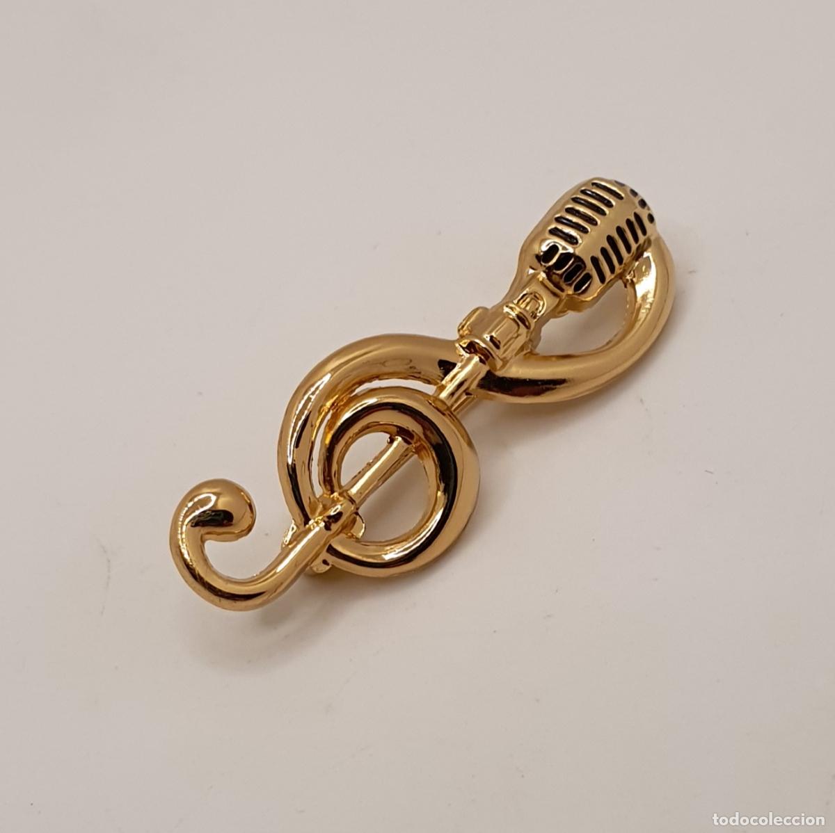 Joyeria: Elegante broche con clave de sol fusionado con micr&oacute;fono estilo vintage ba&ntilde;ado en oro.