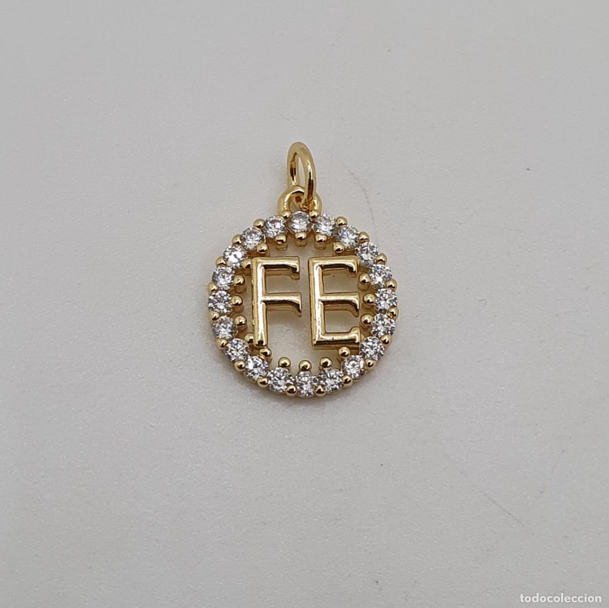 Joyeria: Hermosa medalla chapada en oro con la palabra FE con circonitas talla brillante engarzadas.