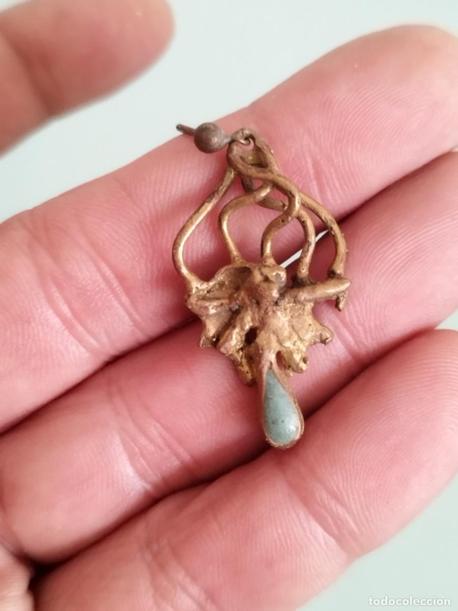 Joyeria: Antiguo pendiente de met&aacute;l intrincado y una piedra peque&ntilde;a en la parte inferior.