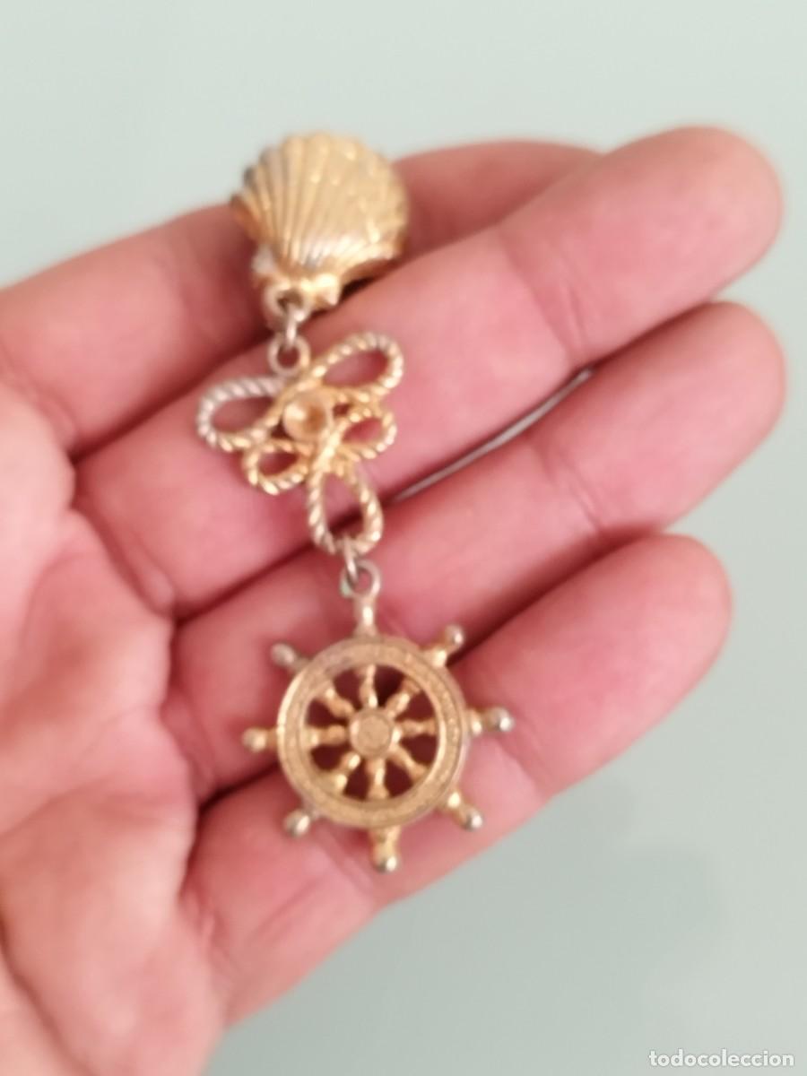 Joyeria: Antiguo pendiente con ancla marinera, lazo y concha marina. De metal dorado a identificar.