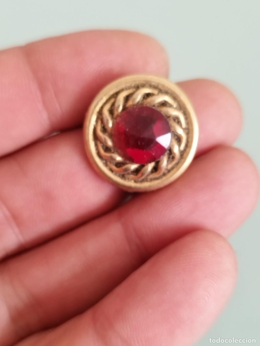 Joyeria: Antiguo adorno de joyer&iacute;a con un centro rojo engastado en un borde dorado trenzado.