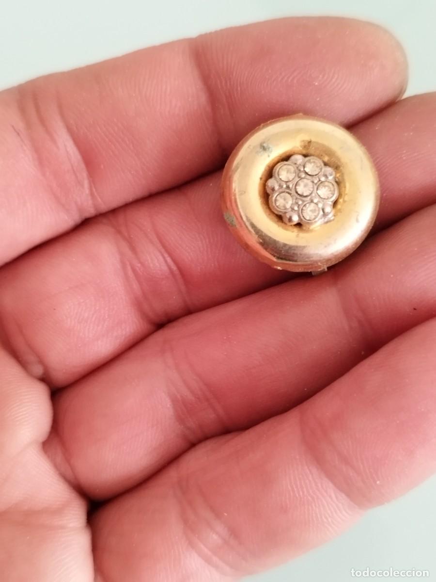 Joyeria: Antiguo pendiente con dise&ntilde;o geom&eacute;trico y detalles brillantes en tono dorado.