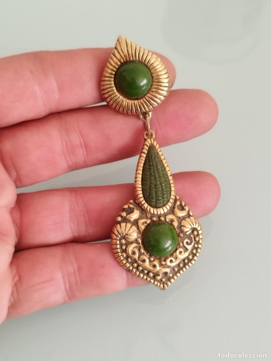 Joyeria: Antiguo pendiente dise&ntilde;o colgante, detalles met&aacute;licos en tono dorado y dos piedras verdes redondeada