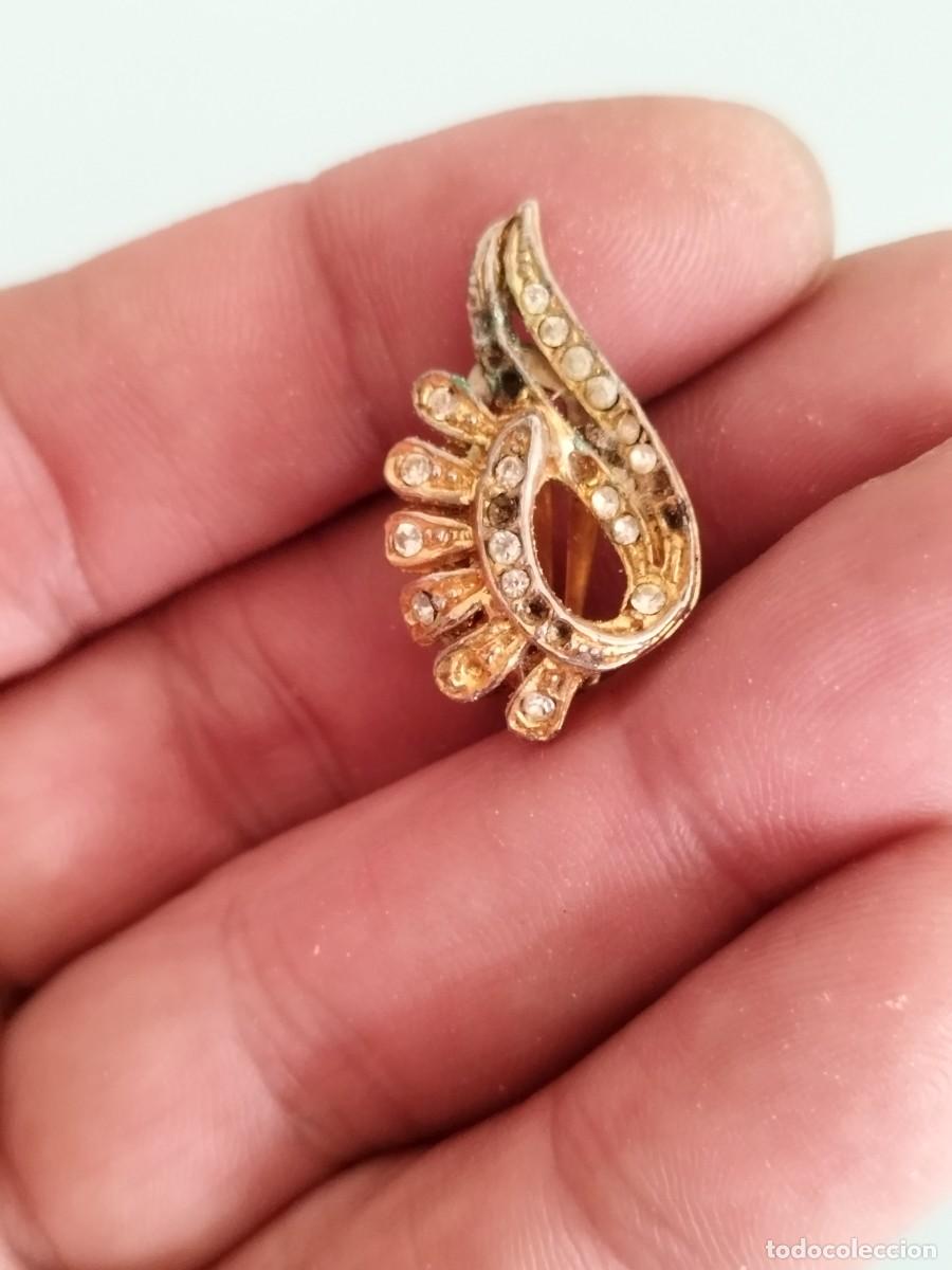 Joyeria: Antiguo pendiente de forma plumas de metal dorado y pedrer&iacute;a a identificar.