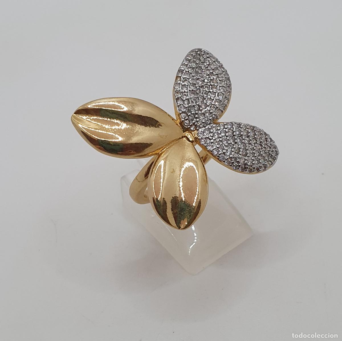 Joyeria: Distinguido anillo de flor con acabados en oro y cuajado de circonitas talla brillante.