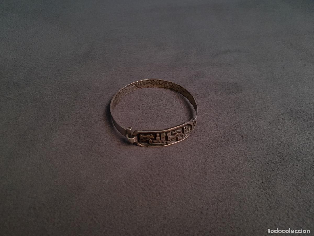 Joaillerie: J-4431.BRAZALETE DE TIPO R&Iacute;GIDO CON CARTUCHO EN PLATA CON RELIEVES HIEROGL&Iacute;FICOS. SIGLO XX.