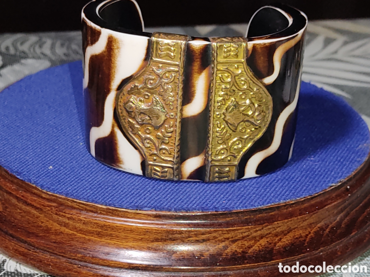 Joyeria: Brazalete o pulsera de baquelita o resina con lat&oacute;n repujado.