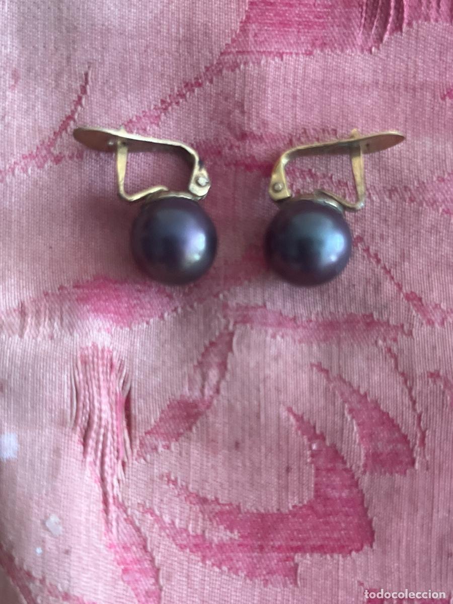 Joyeria: Sencillos pendientes de s&iacute;mil perla negra dormilona, engarzada con metal dorado. Cierre omega. S.XX.