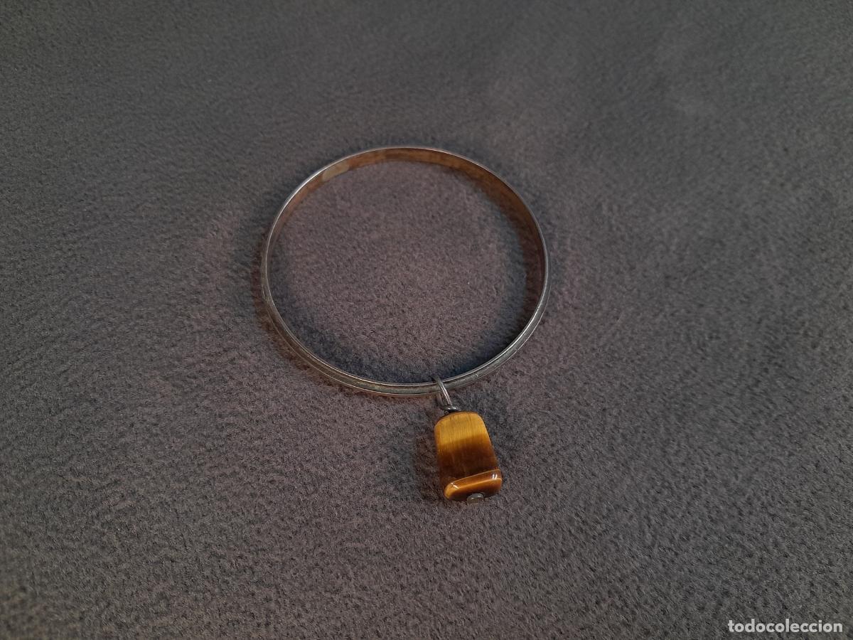 Joaillerie: J-4458. BRAZALETE R&Iacute;GIDO DE PLATA CON COLGANTE DE OJO DE TIGRE. SIGLO XX.
