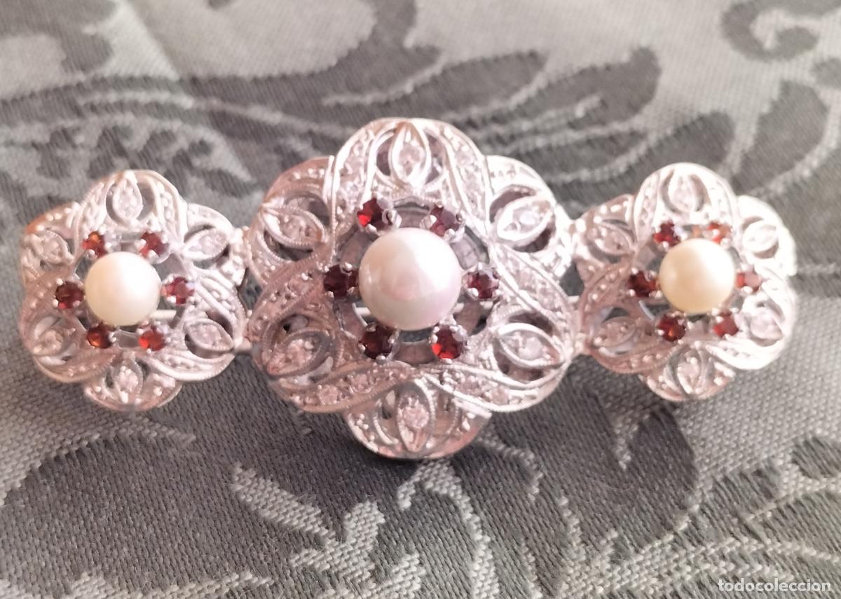 Schmuck: BROCHE DE METAL PLATEADO CON CRISTALES FACETADOS ROJOS, BLANCOS Y PERLAS.