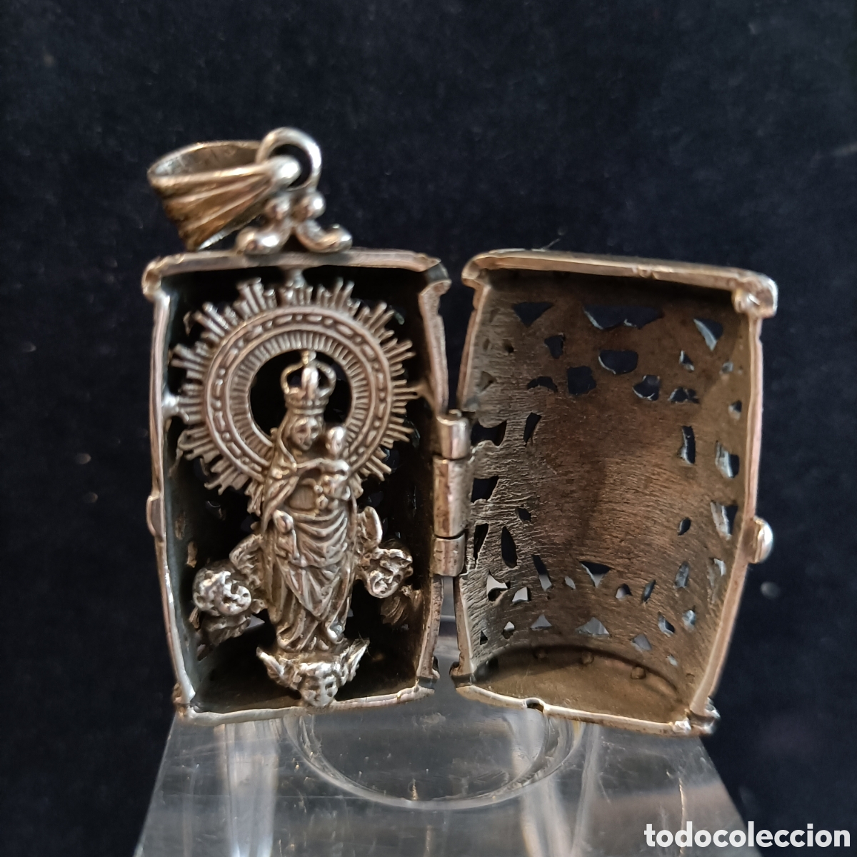 Joyeria: Colgante con forma de relicario, capillita de plata, con la Virgen del pilar en su interior.