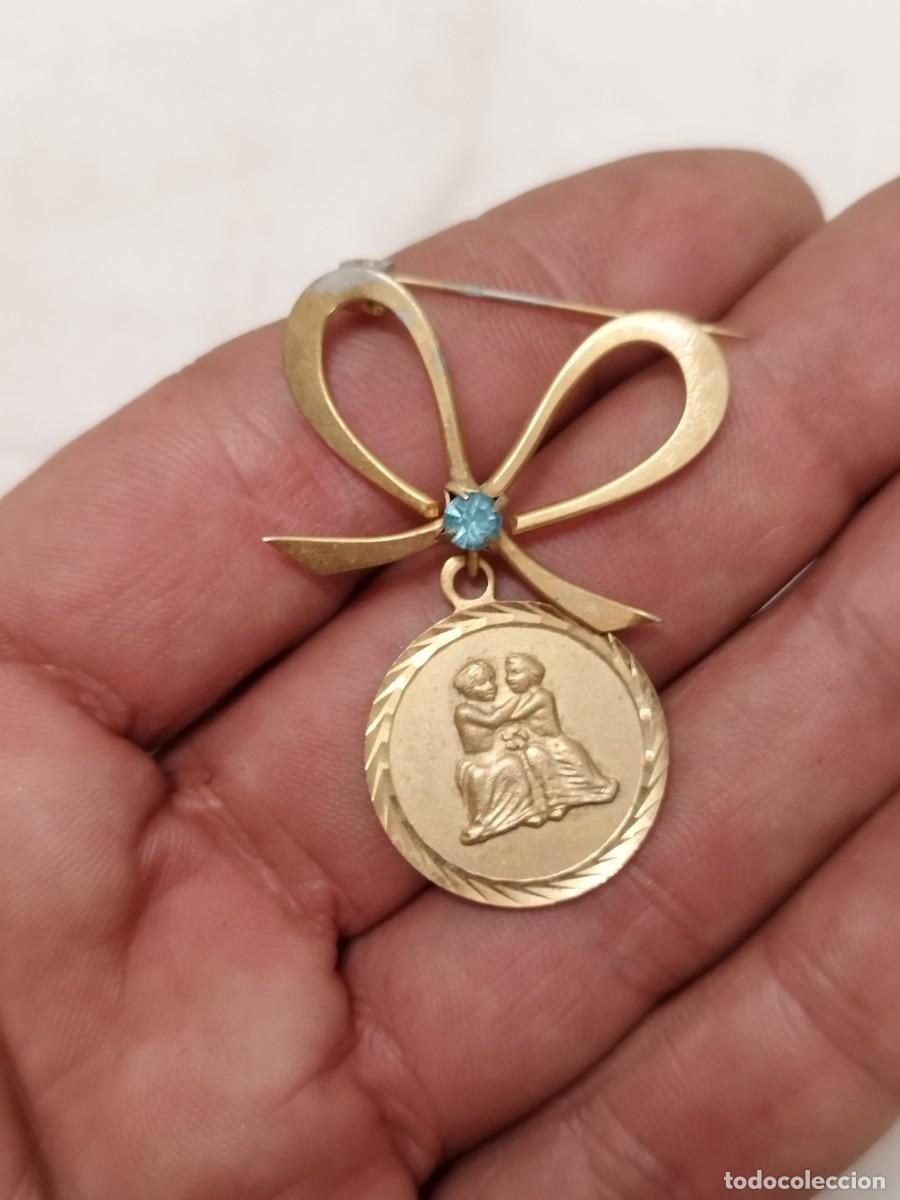 Joyeria: Antiguo Broche colgante con forma de moneda y medall&oacute;n de G&eacute;minis. Medalla y en forma de lazo.