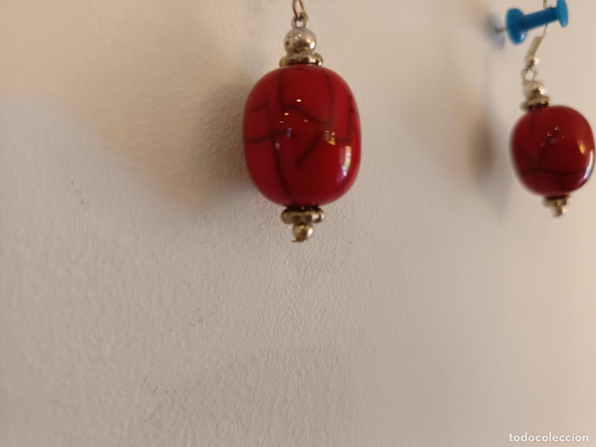 Joyeria: Pendientes artesanales hechos con cuentas de resina roja y detalles met&aacute;licos plateados