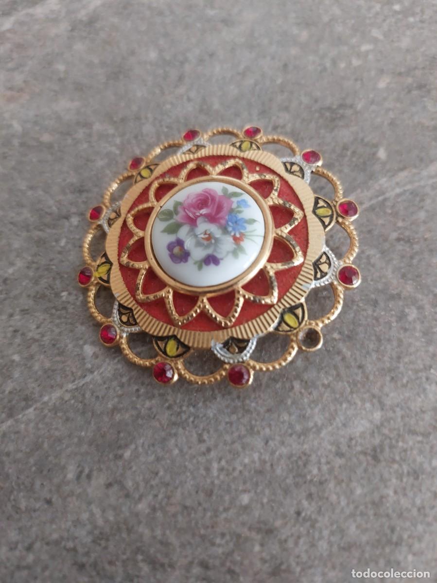 Joyeria: Broche vintage de porcelana damasquinada con centro floral y diamantes de imitaci&oacute;n rojos.