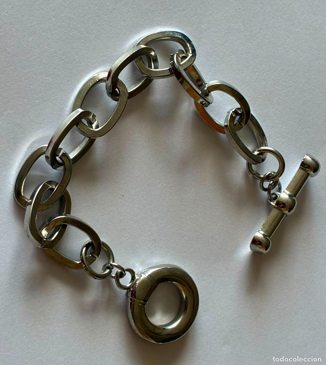 Joyeria: Elegant silver-tone bracelet featuring oversized oval chain links and a stylish toggle clasp. A tim