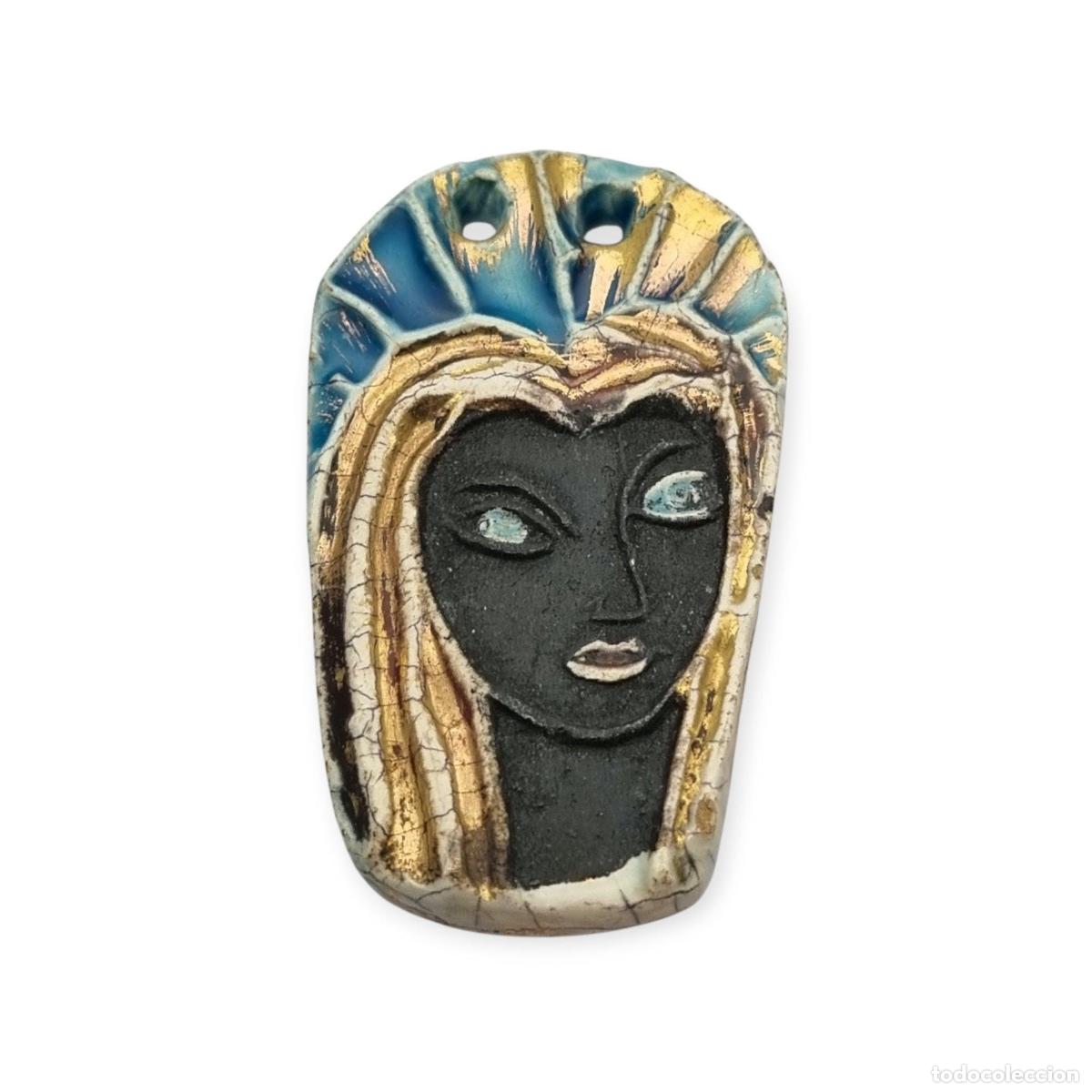 Joyeria: Colgante artesanal de cer&aacute;mica con busto mariano modernista, pieza esmaltada con reflejos dorados, e
