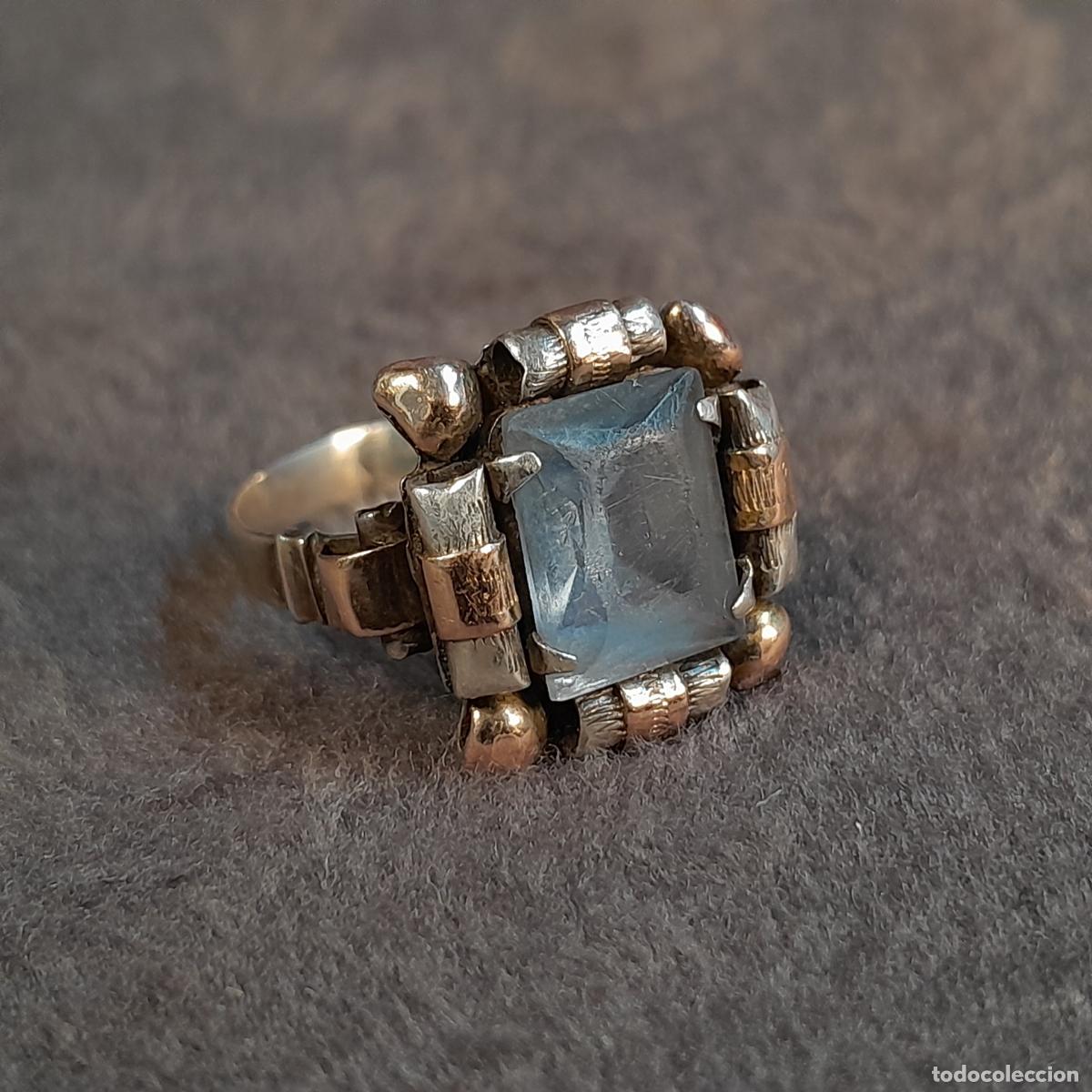 Joyeria: J-4542. ANILLO REALIZADO EN PLATA CON DETALLES EN ORO Y PIEDRA AZUL TALLADA. PRINCIPIOS S. XX.