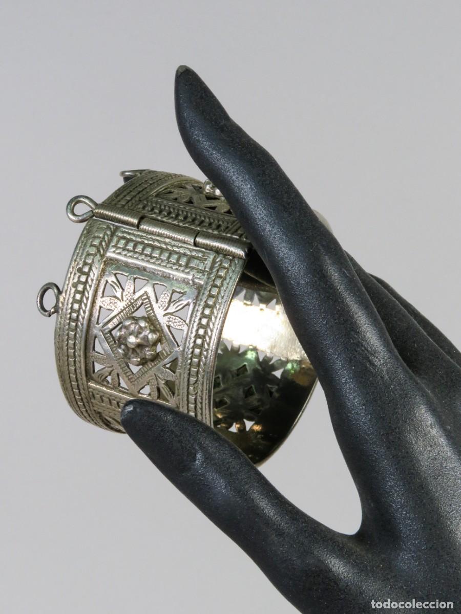 Joyeria: Brazalete Bereber r&iacute;gido articulado en plata repujada con Mano de F&aacute;tima y rosetas Argelia siglo XIX