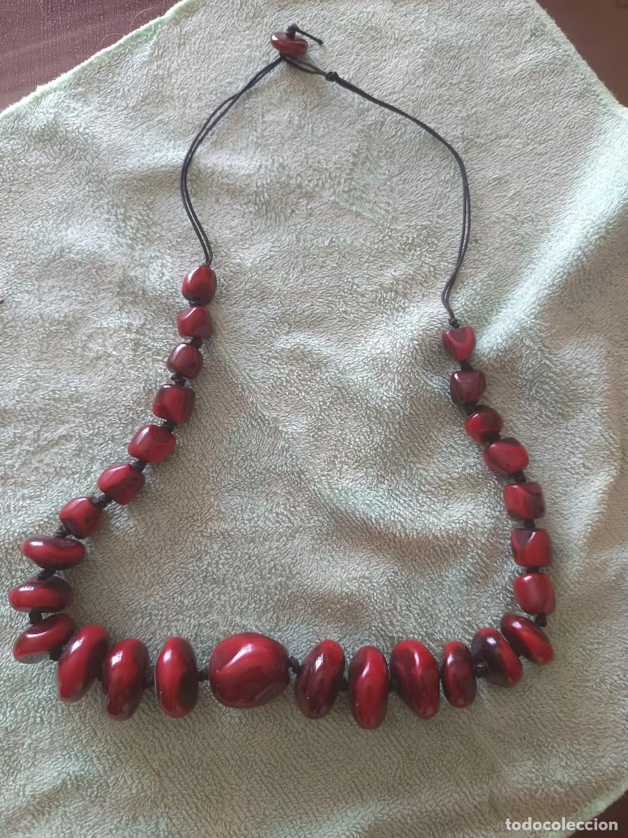 Joyeria: Collar artesanal compuesto por grandes cuentas de tono rojo oscuro con un abalorio central