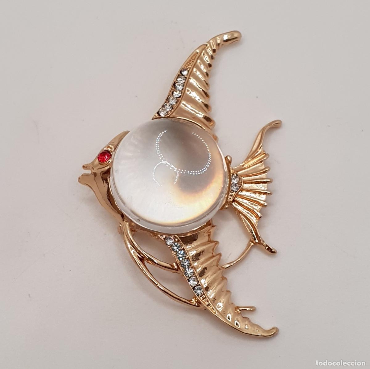 Joyeria: Preciso broche de pez con acabados en oro, circonitas y gran cabuj&oacute;n transparente.