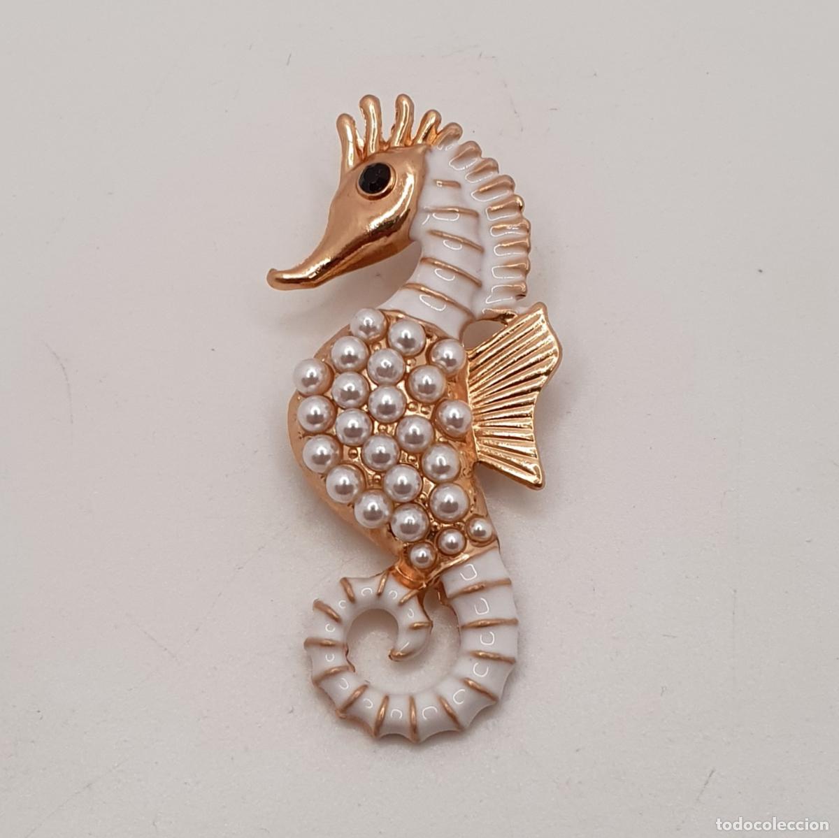 Joyeria: Elegante broche de caballito de mar con acabados en oro, esmaltes al fuego y perlitas blancas.