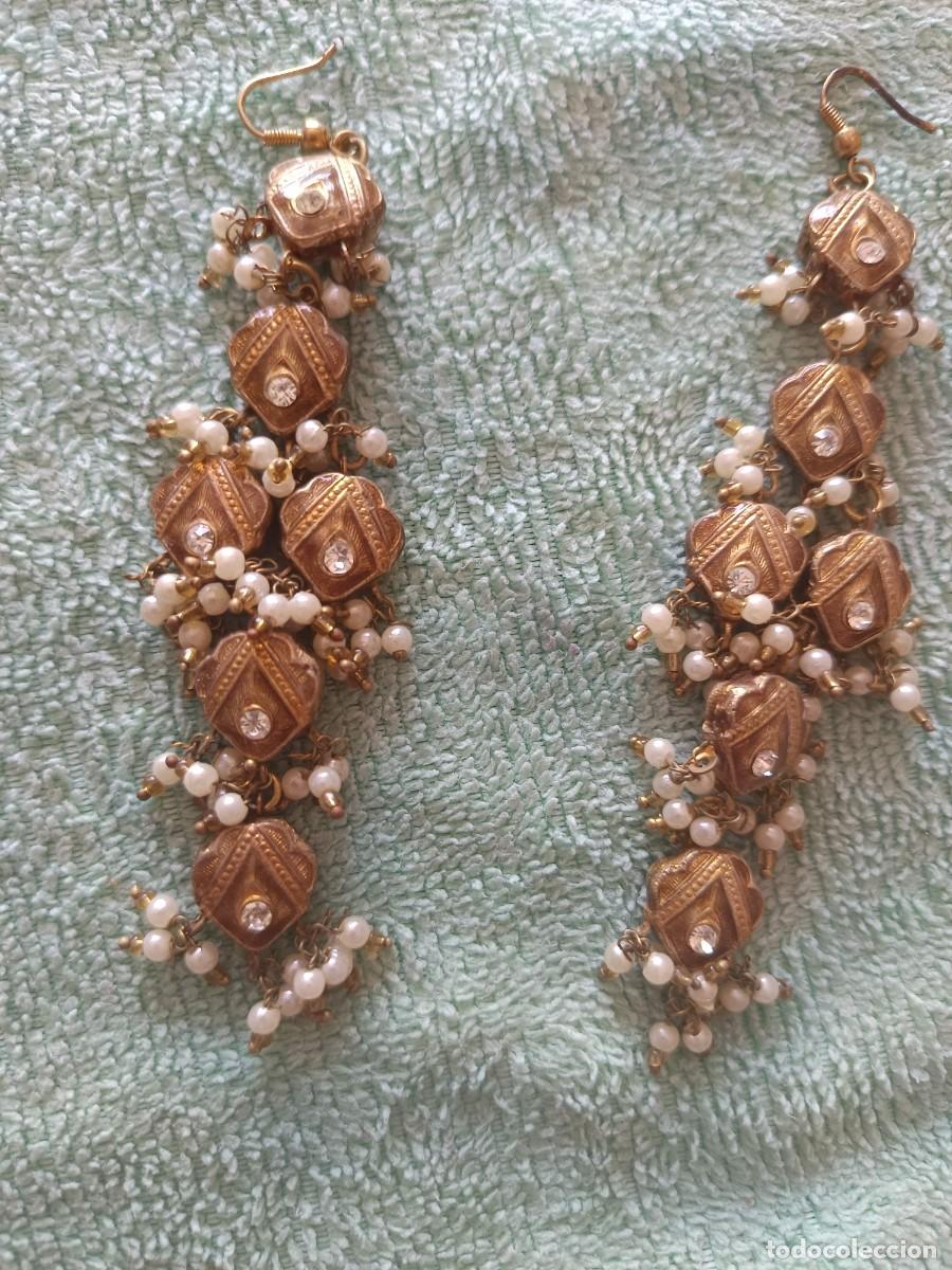 Joyeria: Pendientes largos de estilo tradicional presentan un acabado dorado antiguo con abalorios de perlas
