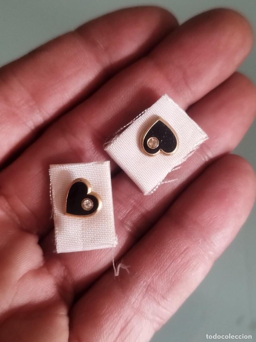 Joyeria: Par o pareja de pendientes, en forma de corazon. Con piedra a identificar en ele centro.