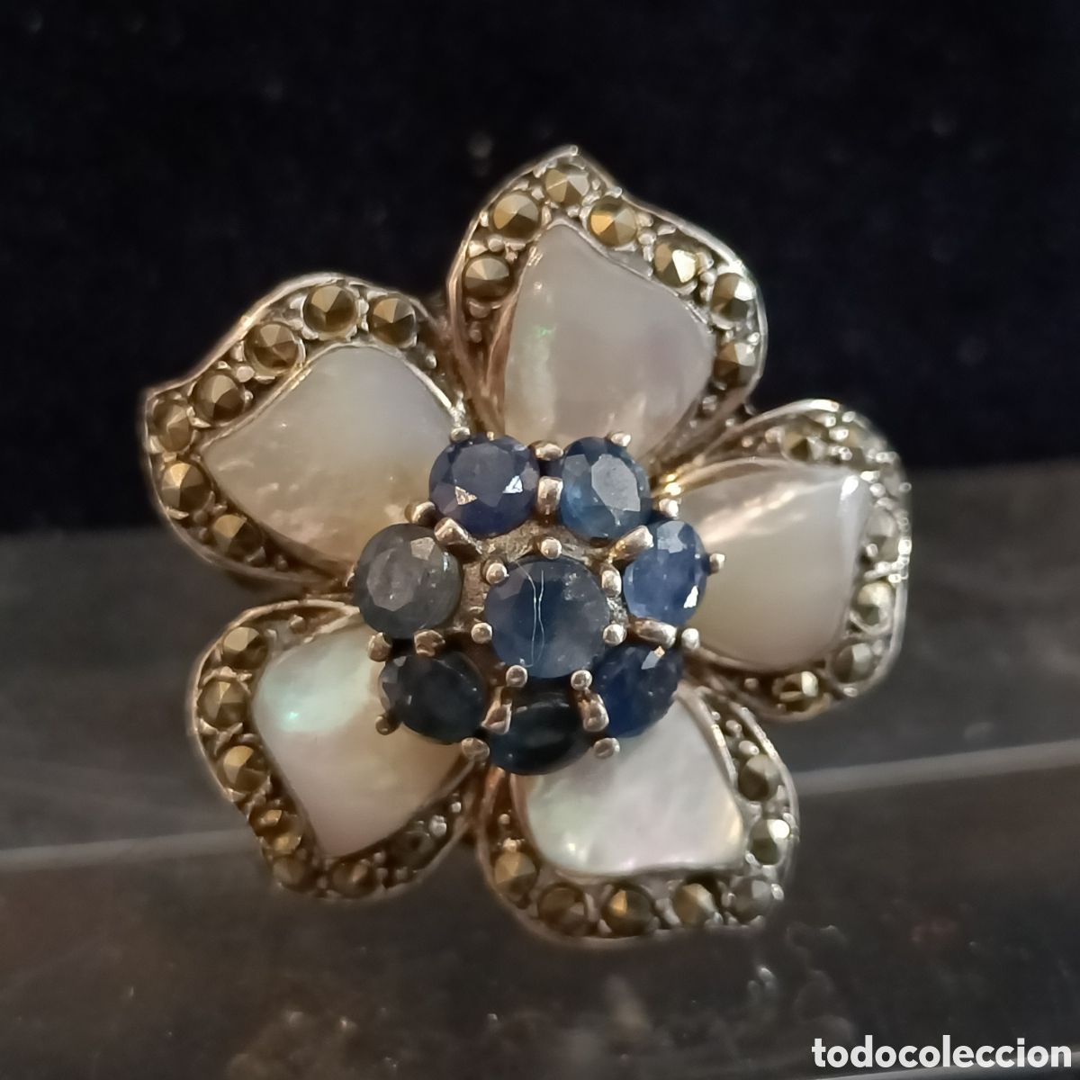 Joyeria: Anillo de plata con forma de flor con nacar, marcasitas y piedras azules.
