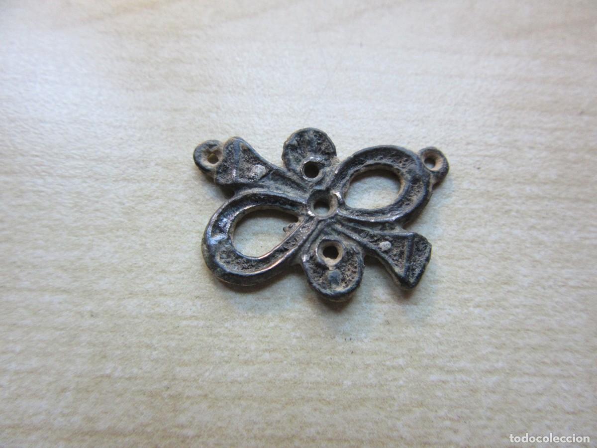 Joalharia: Colgante en forma de lazo de bronce SXVIII-XIX Medidas 2,3 x 1,6 cm