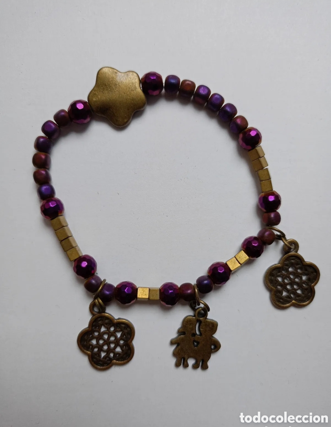 Jewelry: Pulsera morada con detalles de flores y ni&ntilde;os