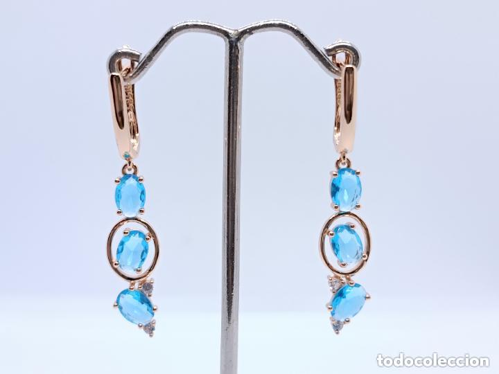 Gioielleria: Elegantes pendientes en oro de 14k contrastado con topacios azules creados