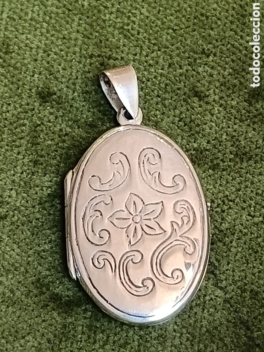 Joyeria: Colgante portafotos de plata con un dise&ntilde;o floral grabado. - Dise&ntilde;o ovalado. - Adorno floral centra